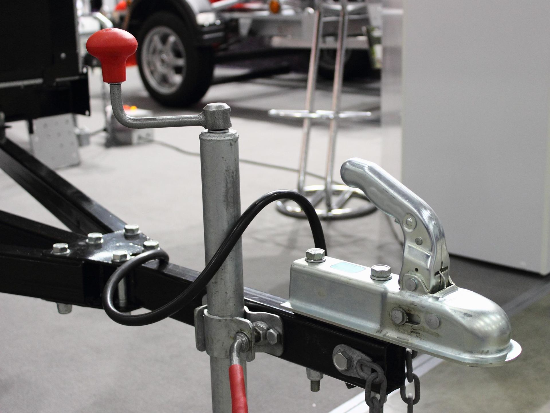 A close up of a trailer with a car in the background.