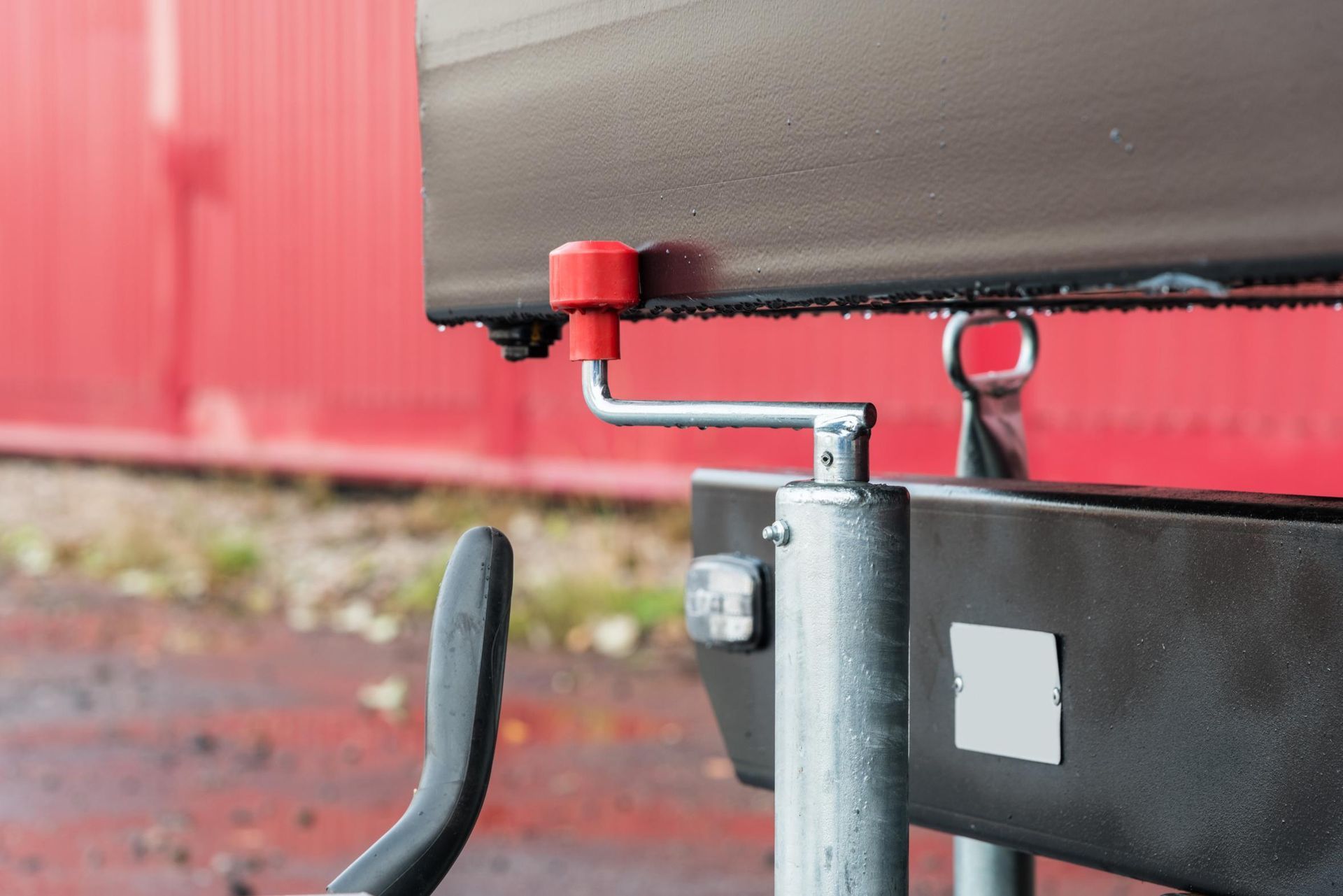 A close up of a trailer with a red handle on it.