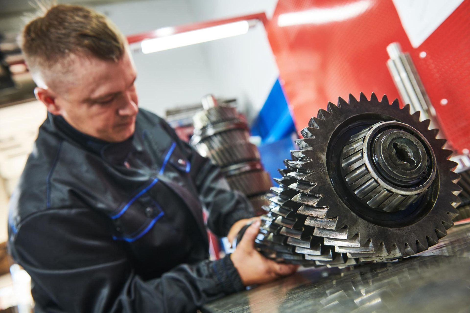 A man is working on a gear in a garage.