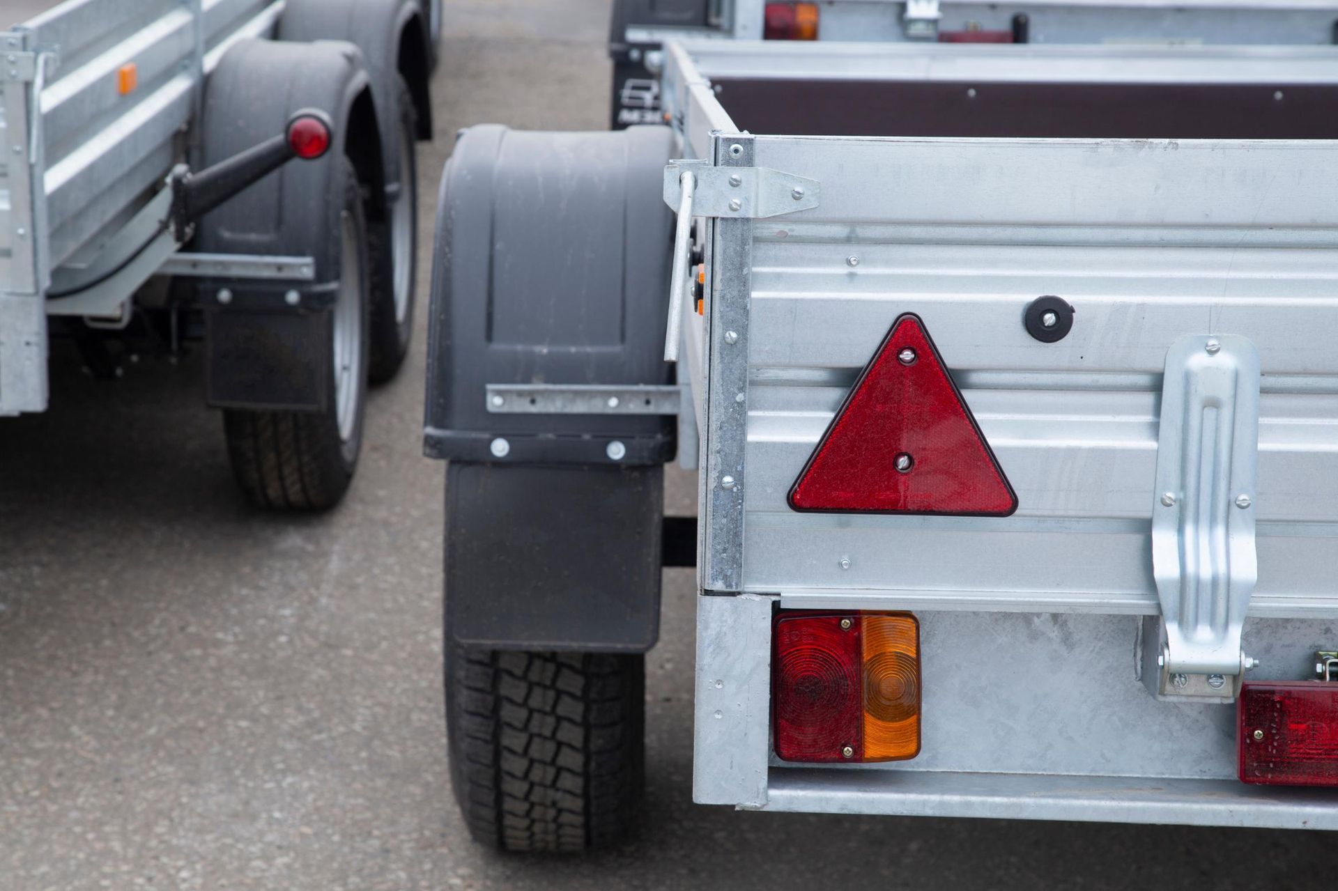 A couple of trailers are parked next to each other on the side of the road.