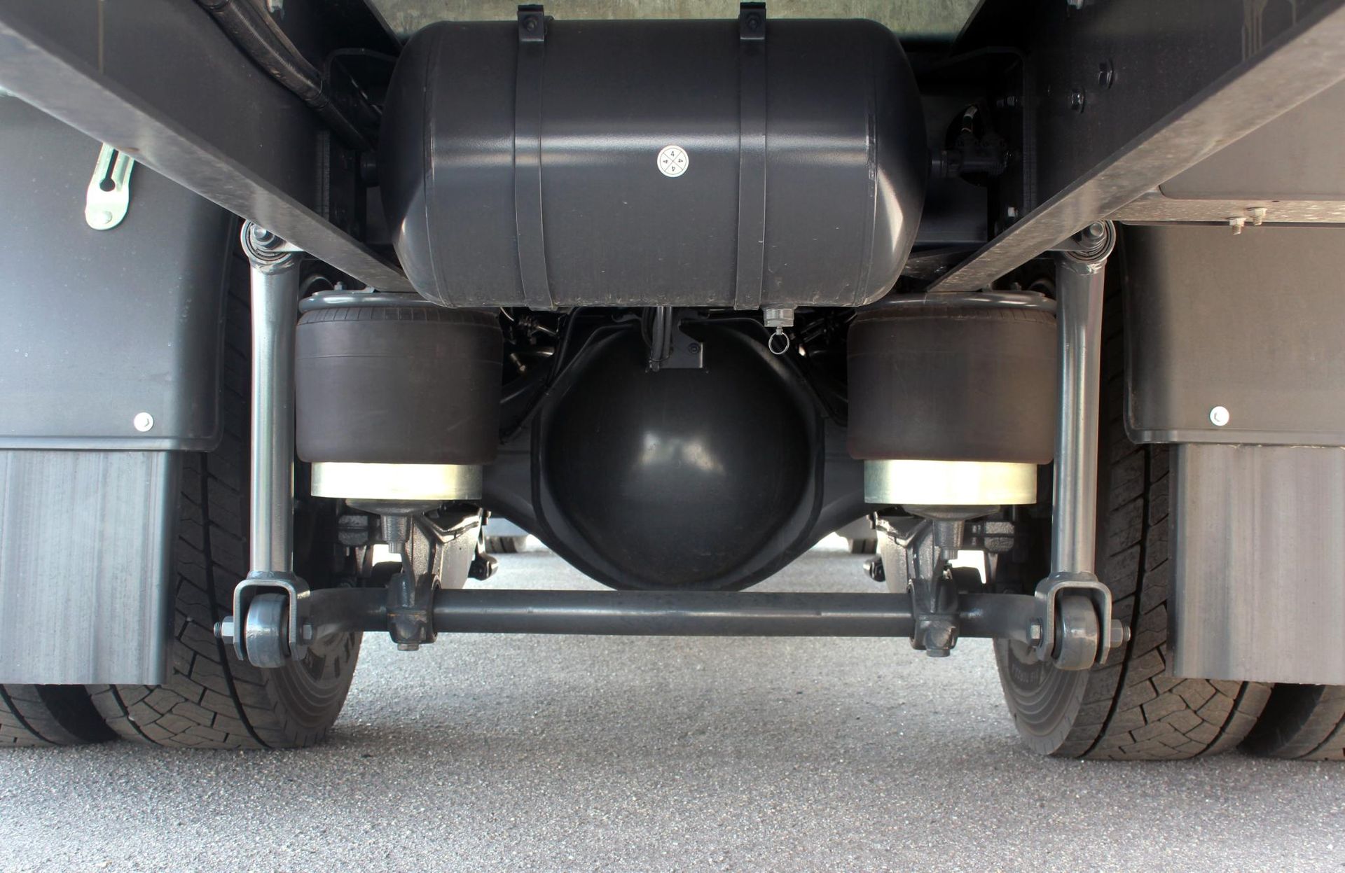 A close up of the underside of a truck 's rear axle.
