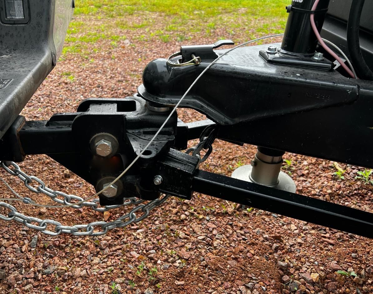 A trailer is attached to a truck with a chain.