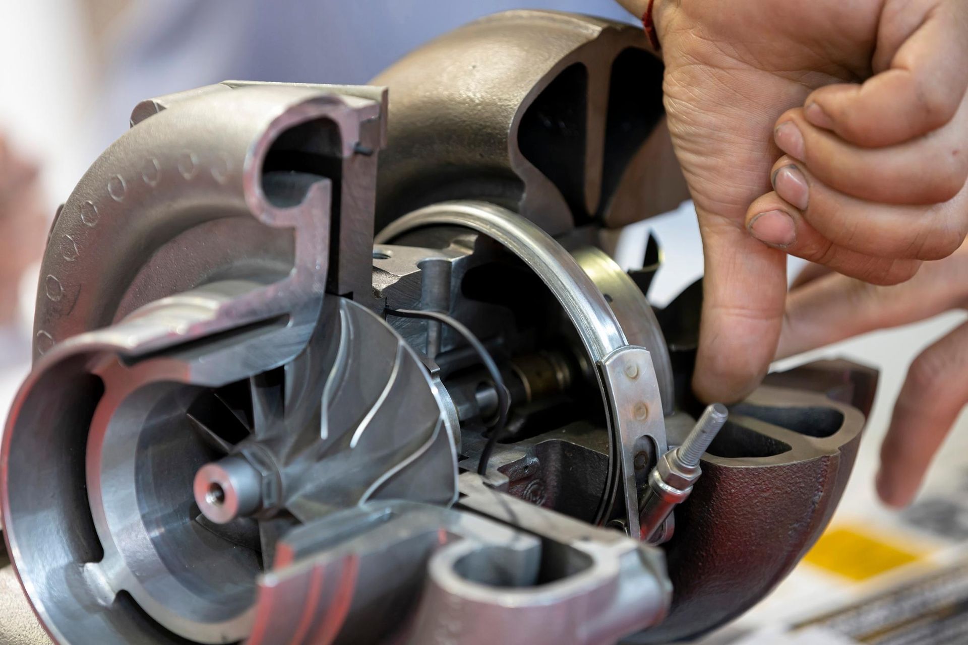 A person is working on a turbocharger with their finger.