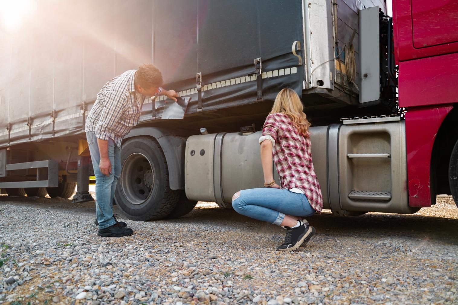 A man and a woman are working on a truck.
