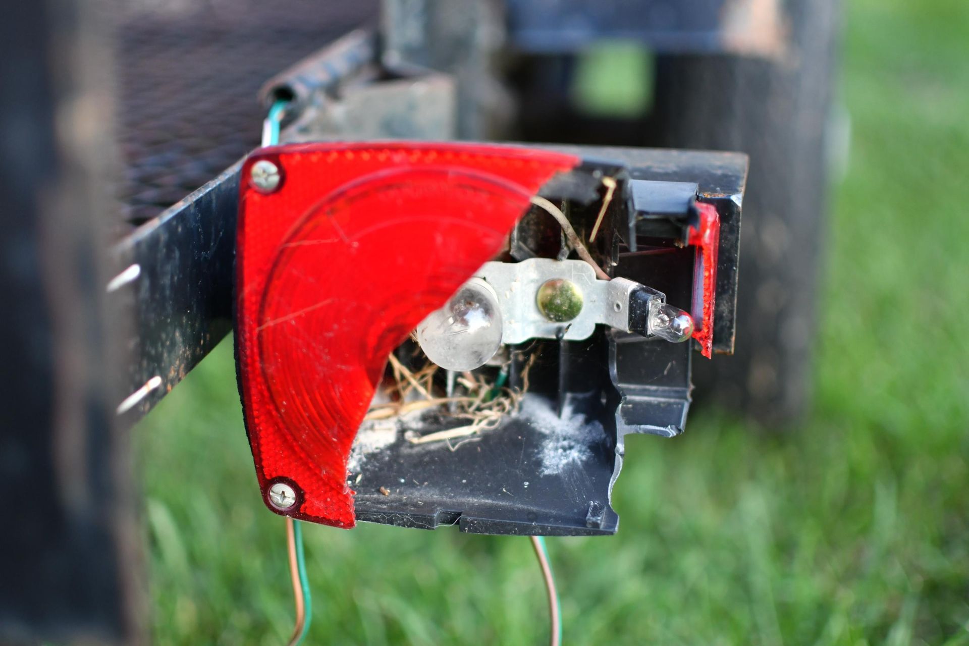 A red and black object is sitting on top of a lush green field.