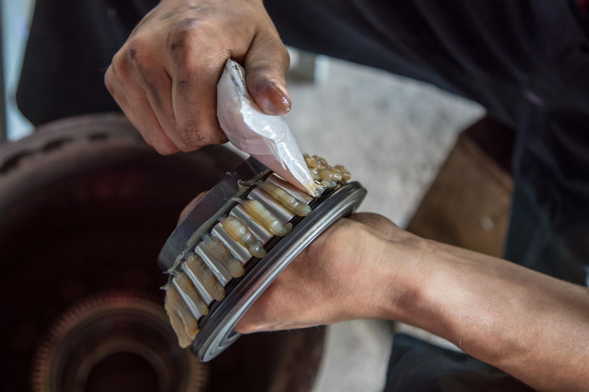A person is cleaning a bearing with a brush.
