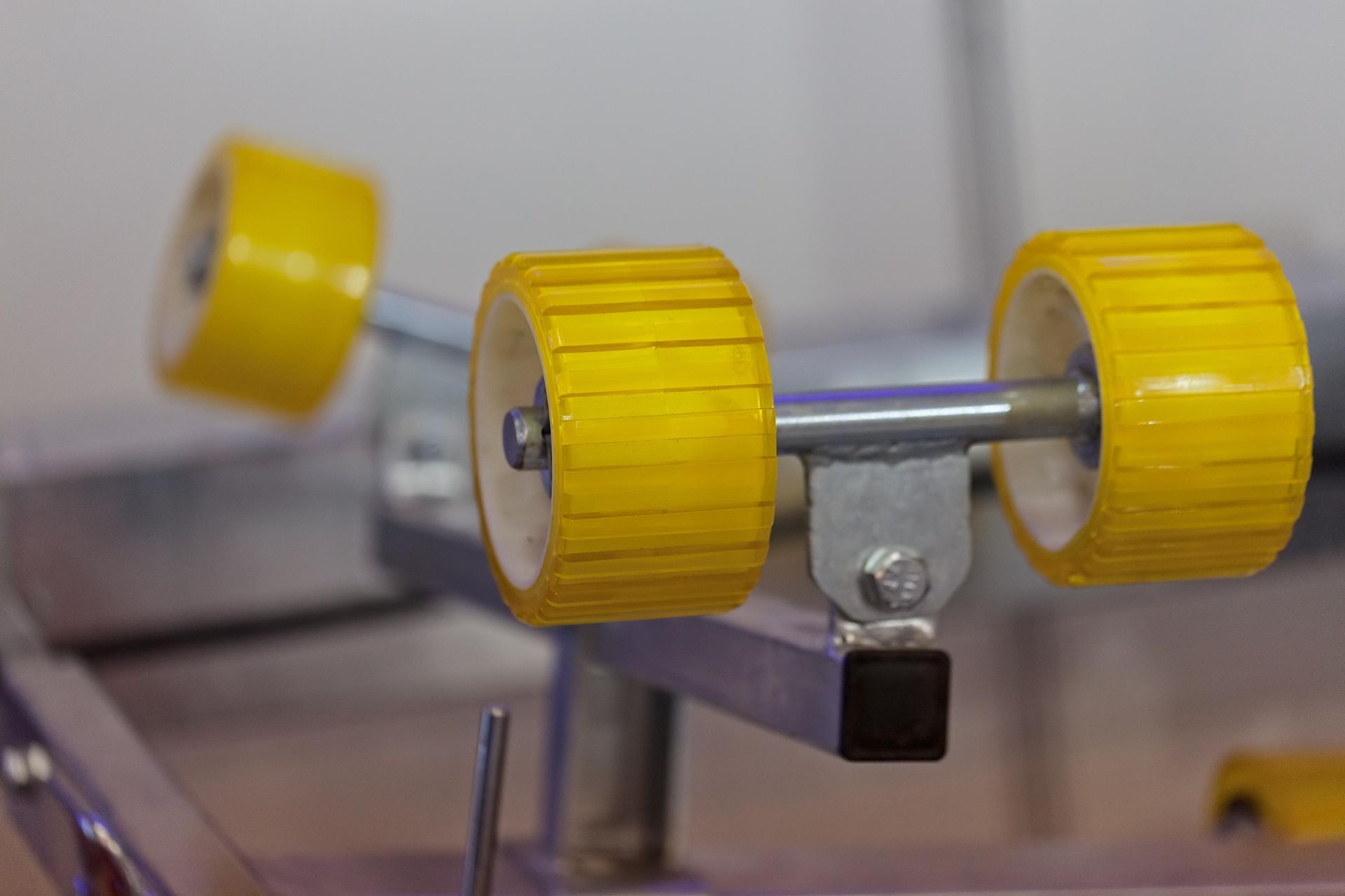 A close up of a pair of yellow wheels on a metal frame.