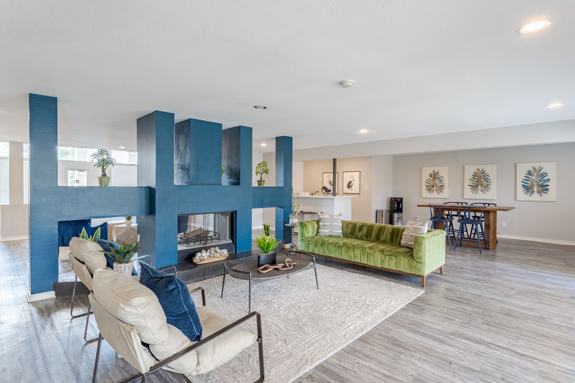 A large room with stairs leading up to it and a desk in the middle of it at Baystone Apartments in Webster, TX.