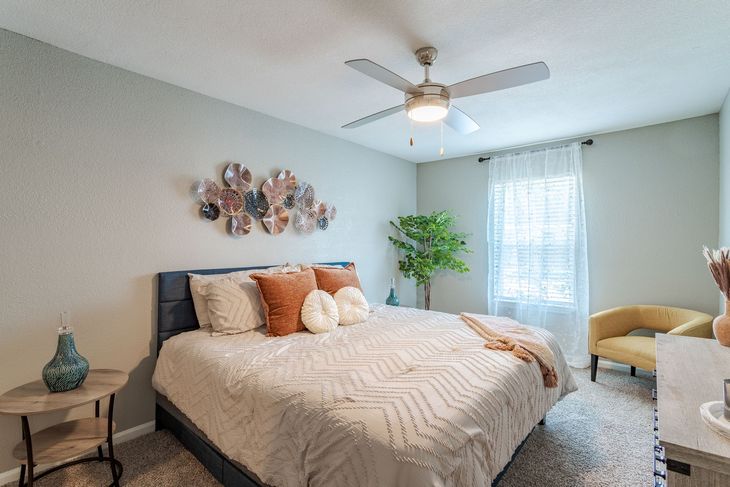 Bedroom with a bed, nightstand, dresser, and wall art. Turquoise, yellow, and gray color scheme.
