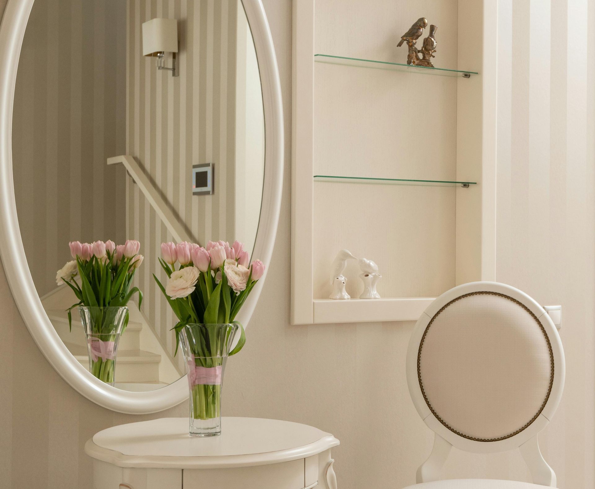 A vanity with a mirror and a vase of flowers on it