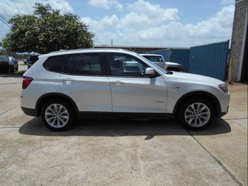 A white bmw x3 is parked in a parking lot.