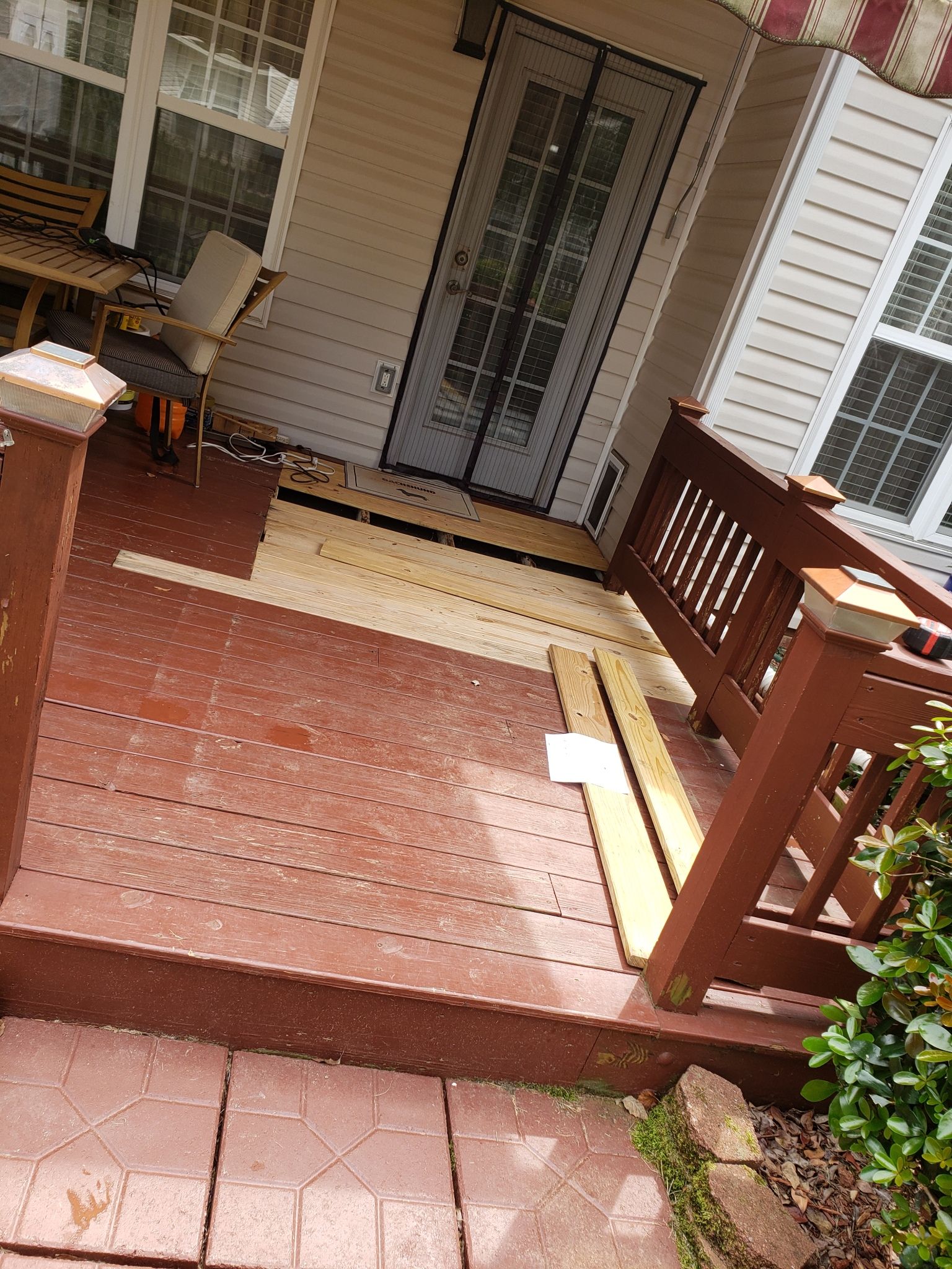 A porch with a wooden railing and stairs leading up to it.