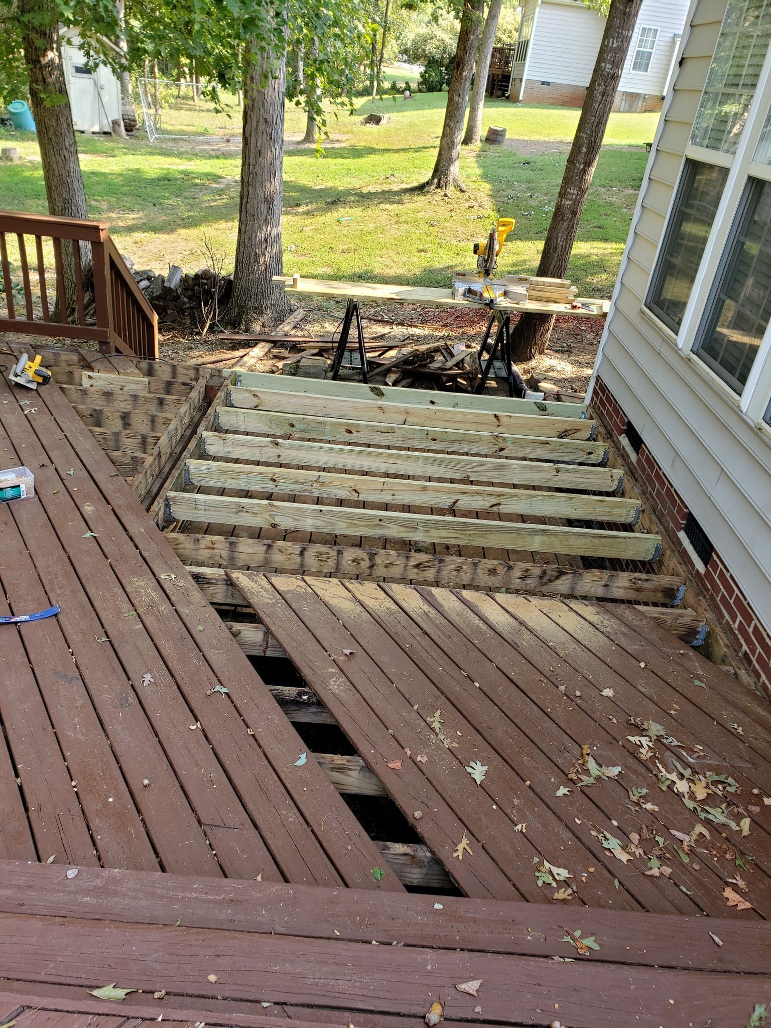 A wooden deck is being built on the side of a house.