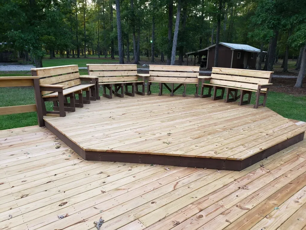 A wooden deck with a stage and benches on it