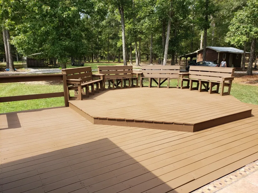 A wooden deck with a stage and benches on it