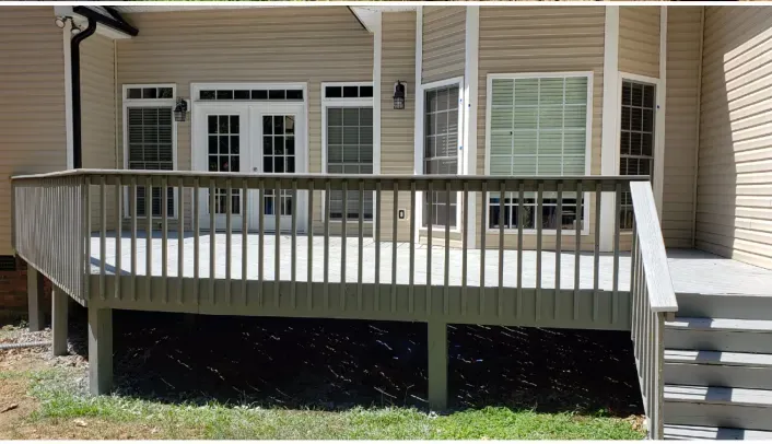 A house with a deck and stairs in front of it