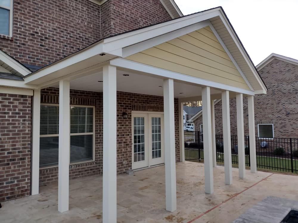 A brick house with a porch with white columns