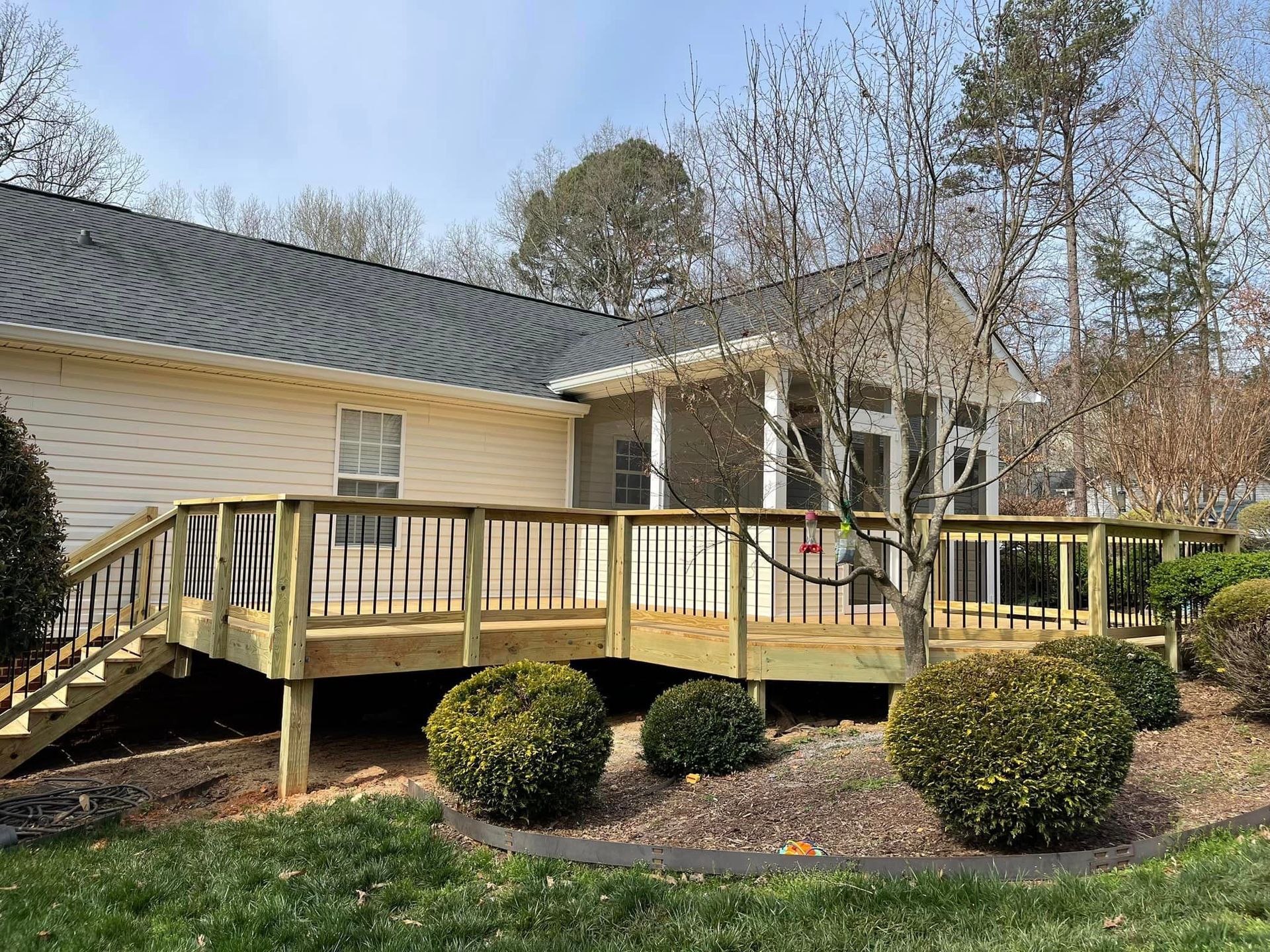 A house with a wooden deck and stairs in front of it.