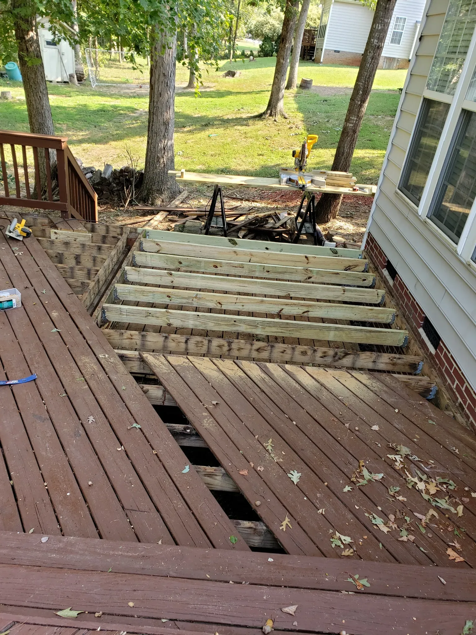 A wooden deck is being built next to a house.