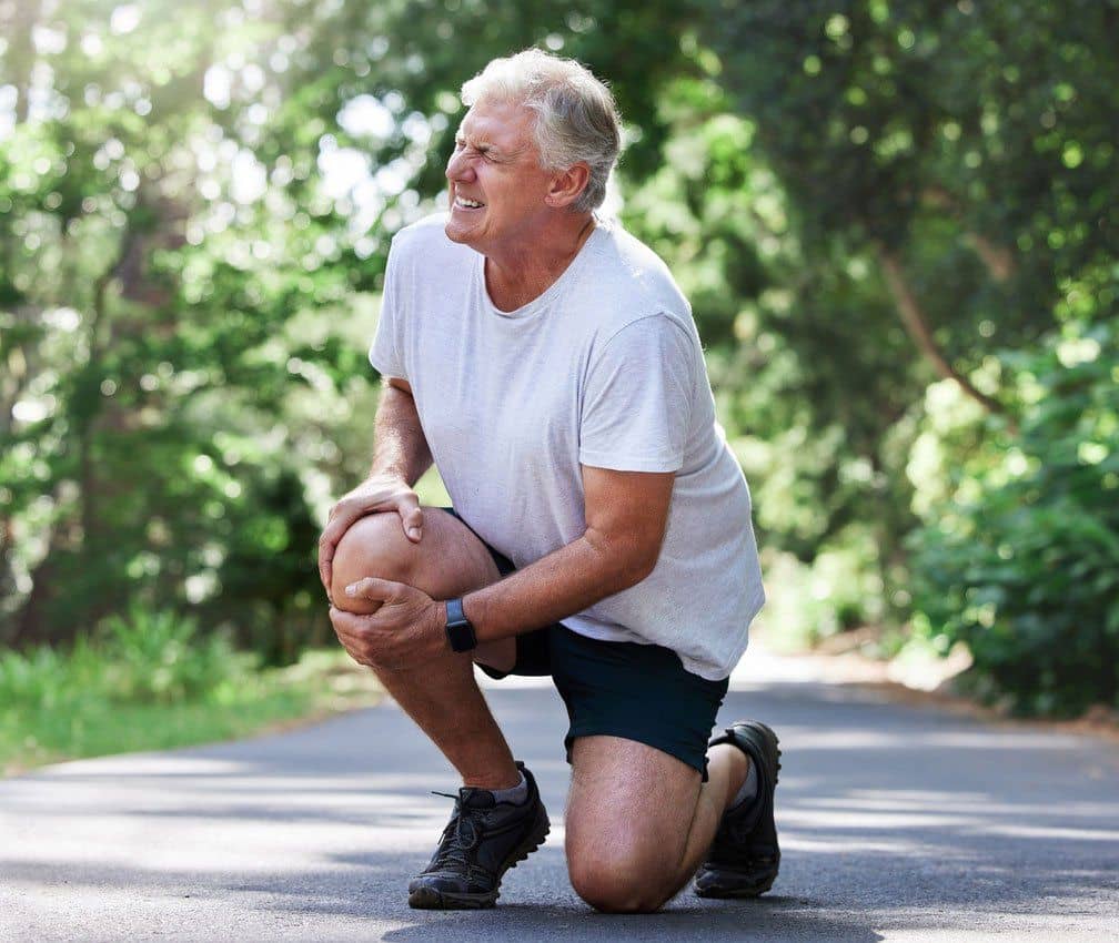 Shot of a mature man experiencing knee pain while exercising outdoors