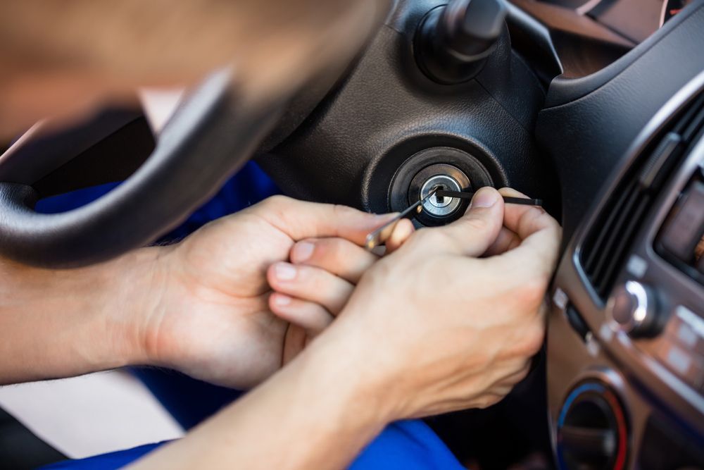 Person's Hand Inserting Lockpickers Tools In Key Hole