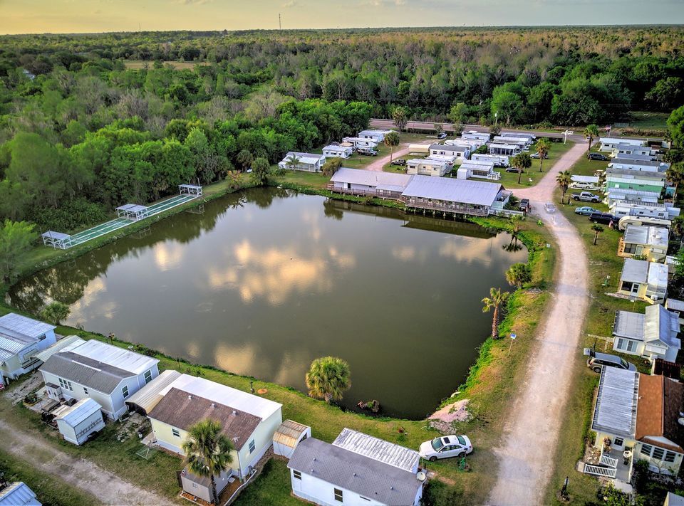 an aerial view of a mobile home park with a lake in the middle