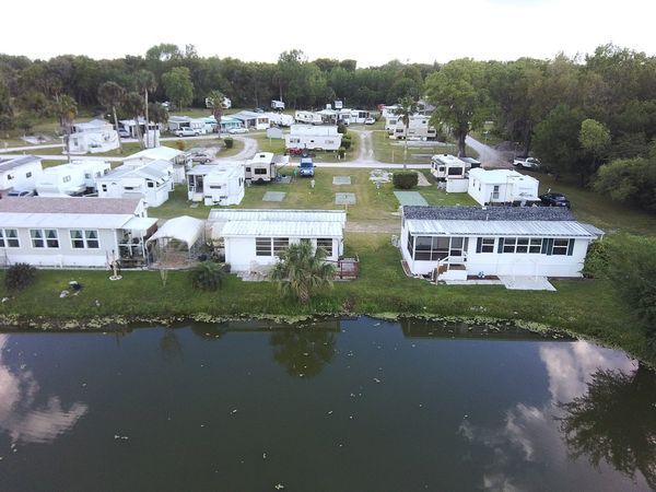 an aerial view of a mobile home park with a lake in the middle .
