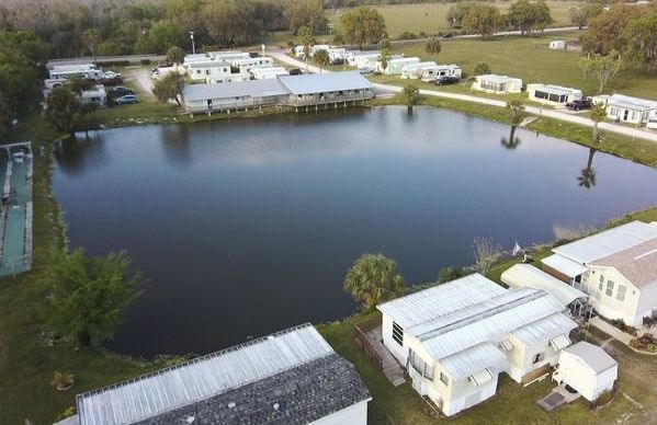 an aerial view of a mobile home park with a large lake in the middle .