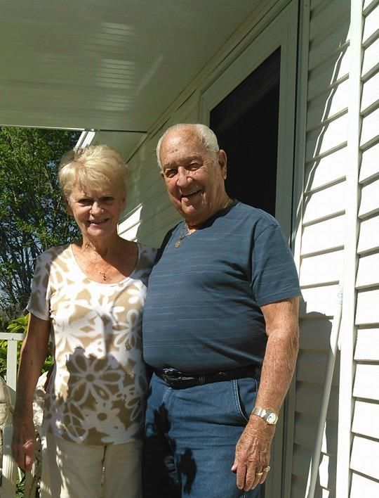 a man and a woman standing in front of a white house