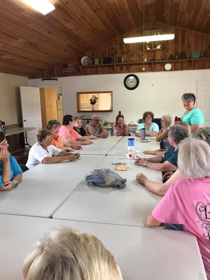a group of women are sitting around a long table