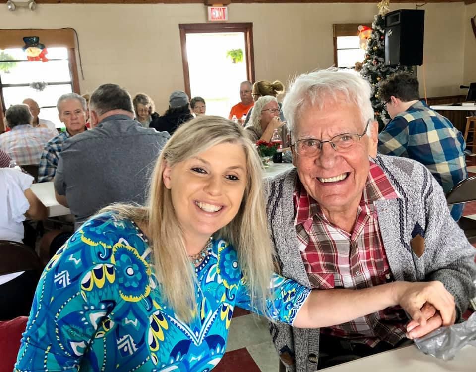 a man and a woman are posing for a picture in front of an exit sign