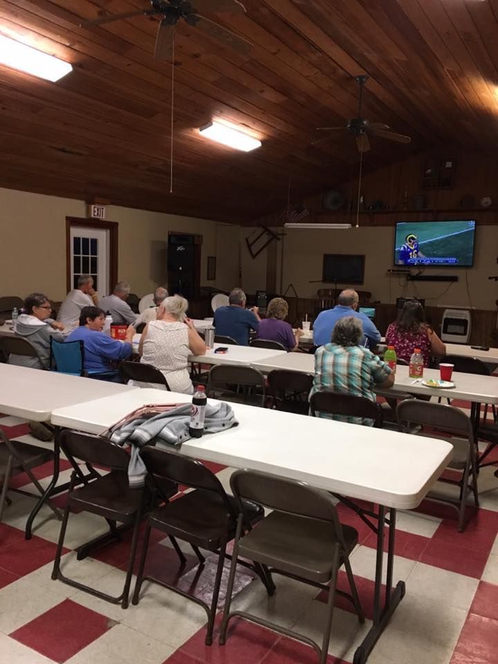a group of people sitting at tables watching a football game