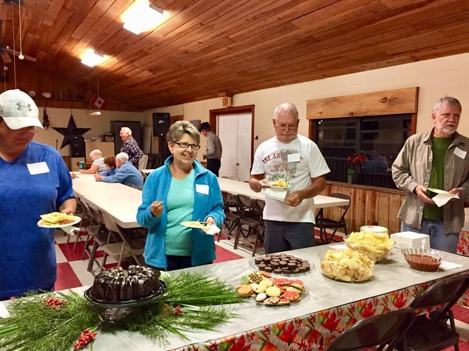 a group of people standing around a table with a man wearing a t-shirt that says ' texas ' on it