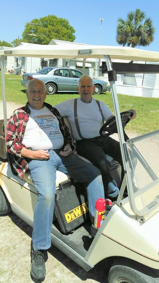 two men are sitting in a golf cart with a dewalt toolbox on the back