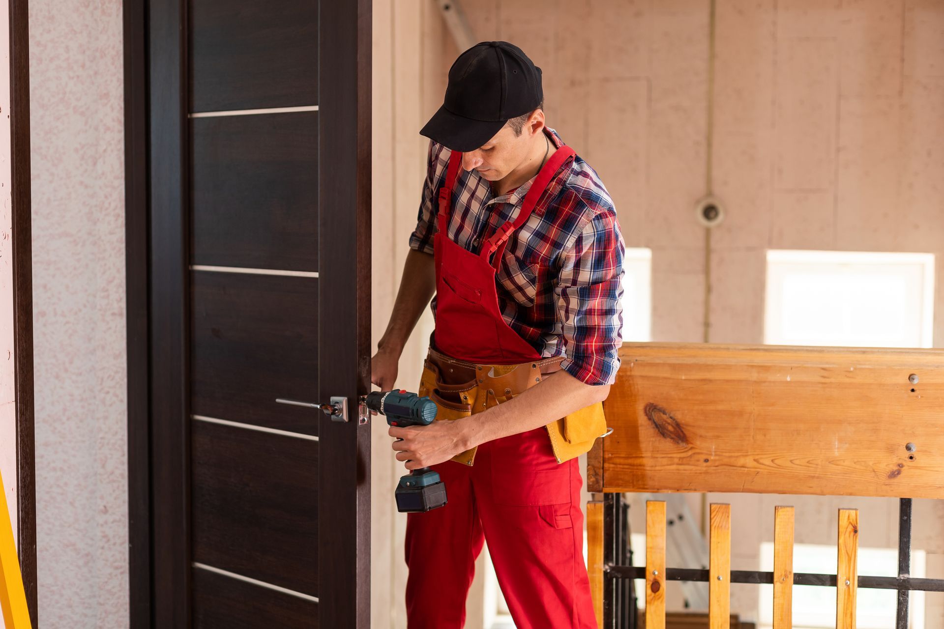 A worker with a screwdriver installing a door.
