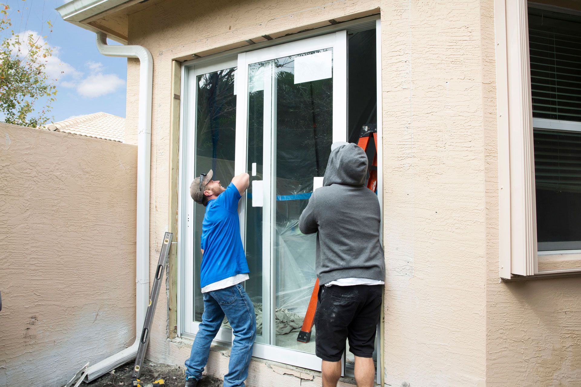 Experienced contractors installing a sliding glass patio door.