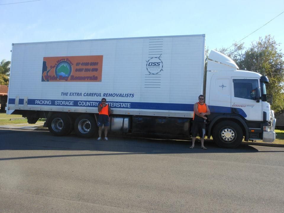 Two Men Are Standing in Front of a Large White Truck — Wide Bay Removals In Dundowran, QLD