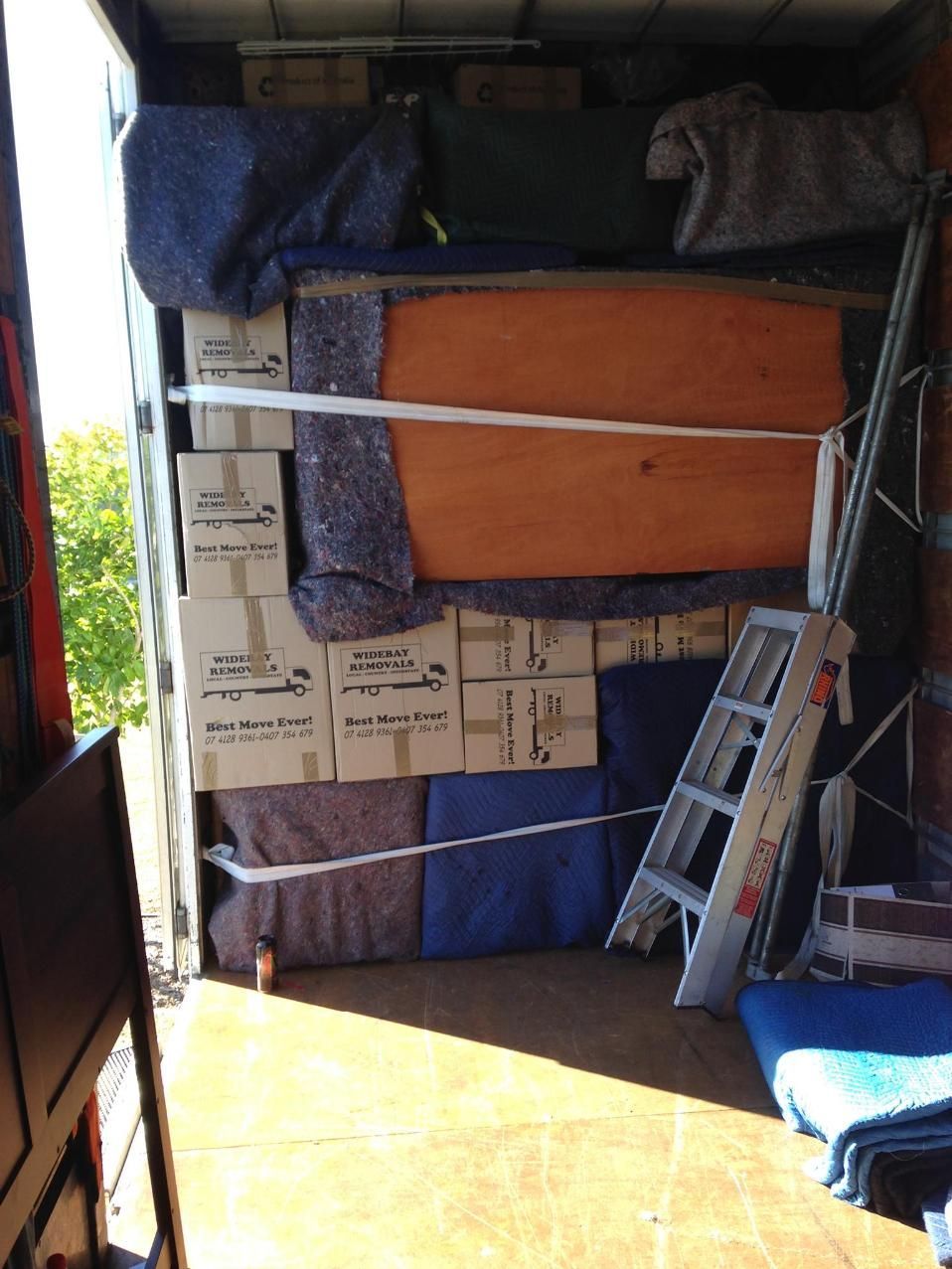 The Back of a Truck Filled With Boxes and a Ladder — Wide Bay Removals In Dundowran, QLD