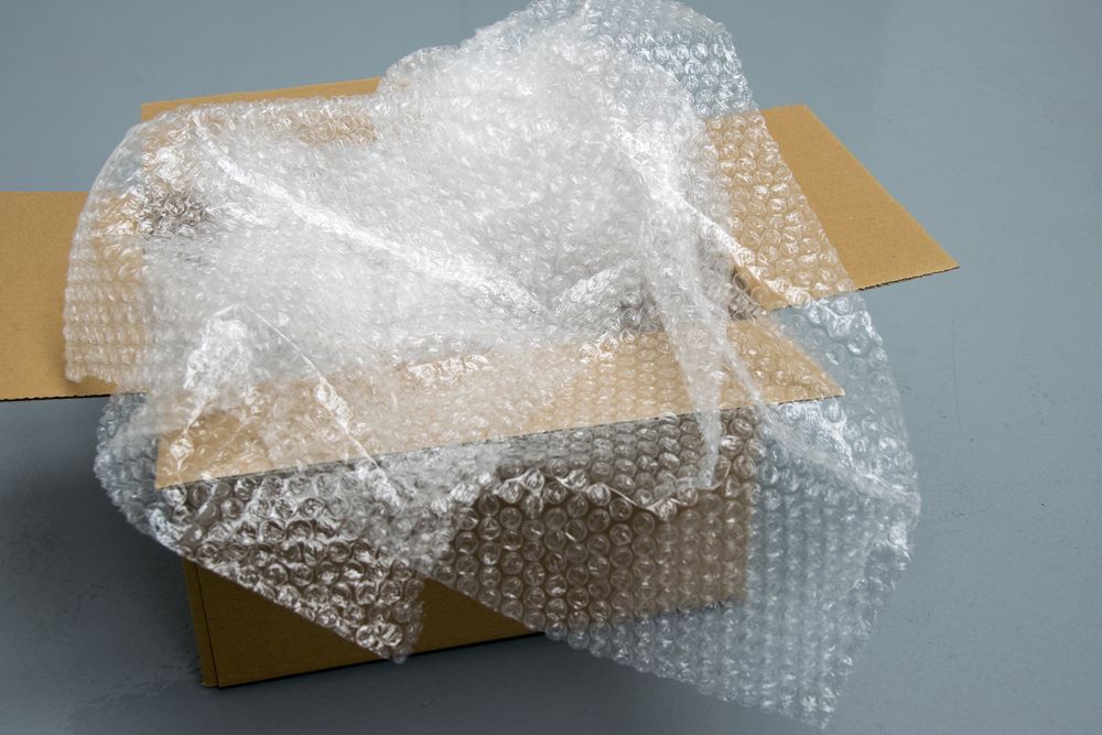 A Cardboard Box Covered in Bubble Wrap on a Table — Wide Bay Removals In Dundowran, QLD