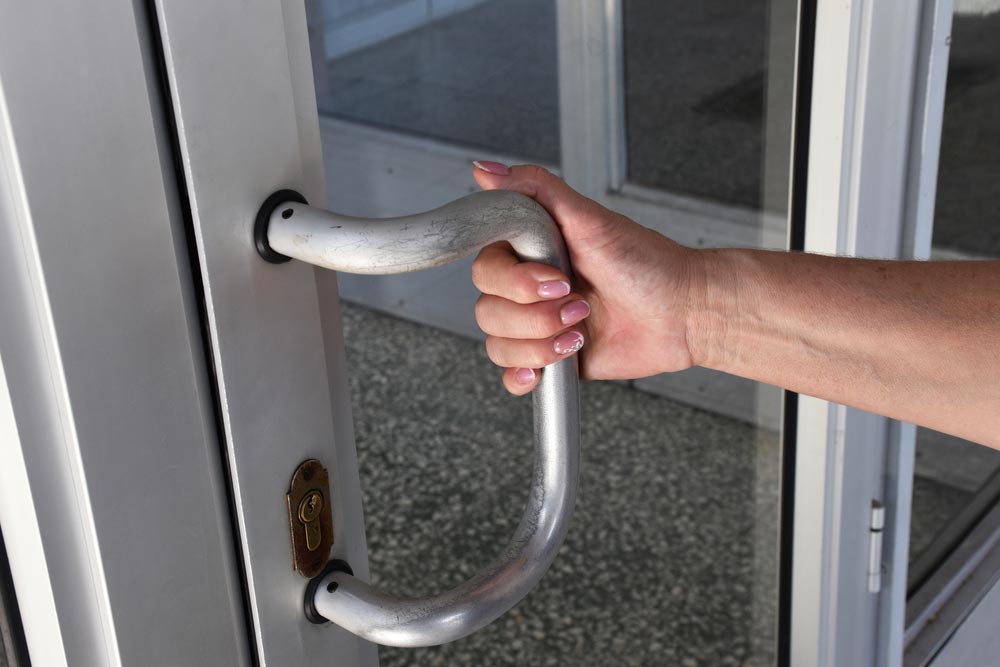 Woman Trying To Open A Locked Office Door — Locksmith In Bendigo, VIC