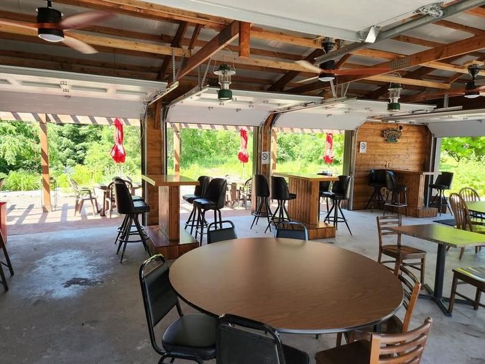 A restaurant with tables and chairs and a ceiling fan.