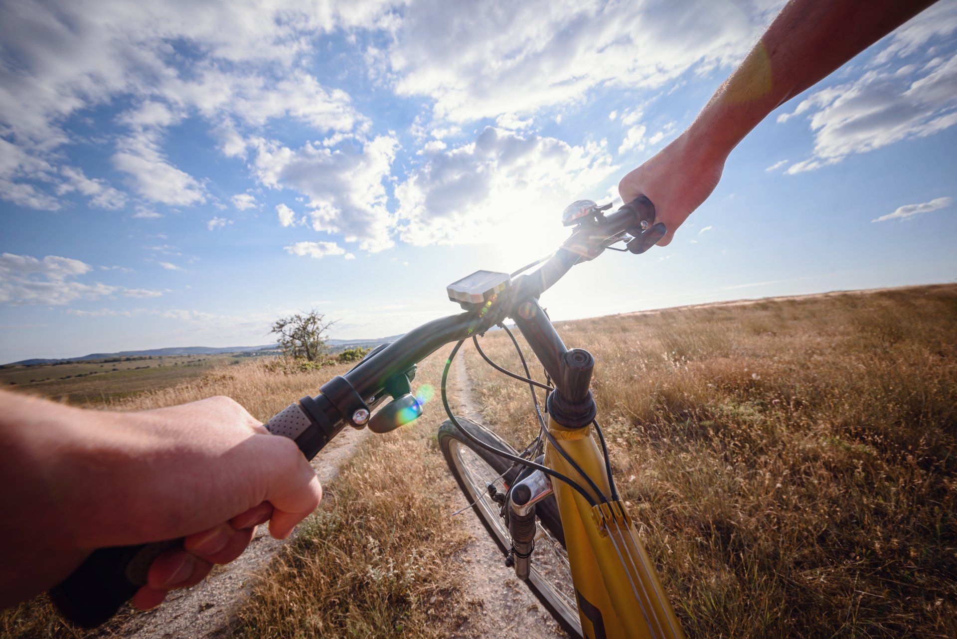 Bike handle bar with lake and sunshine in the background. focus on bike handle bar. picturesque village road at sunset