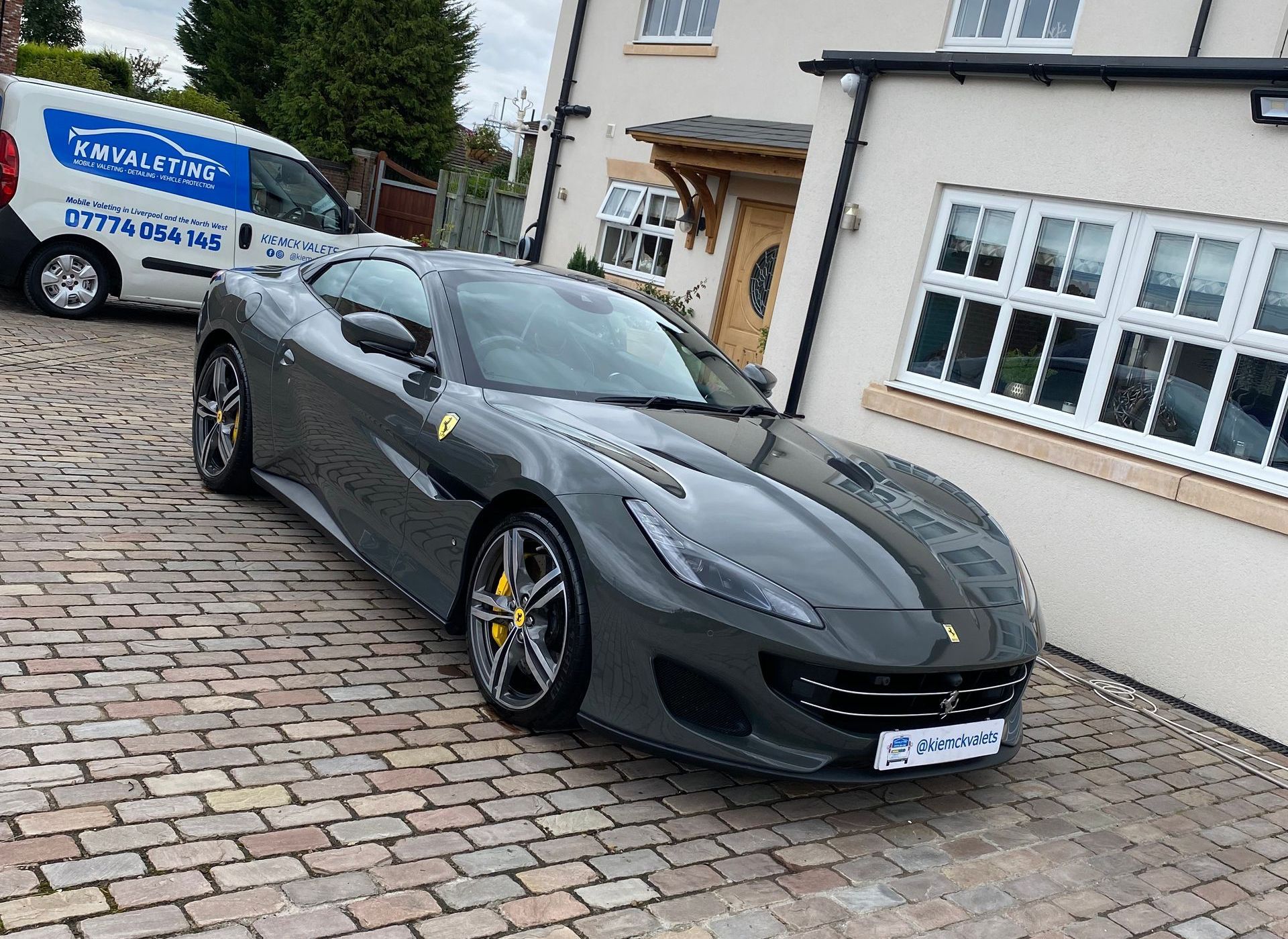 A gray sports car is parked in front of a house.