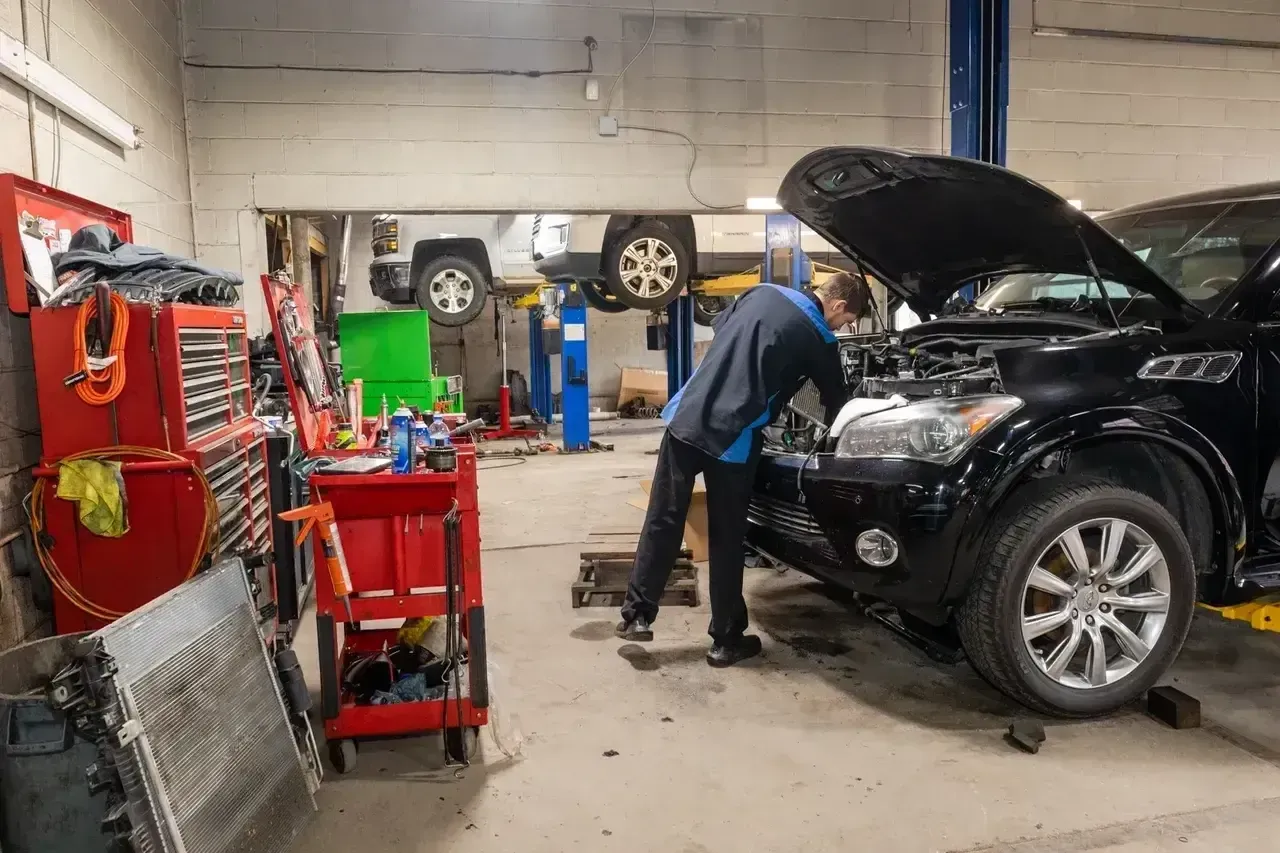 A Mechanic Is Working on a Car in a Garage With the Hood Up | Professional Auto Repair