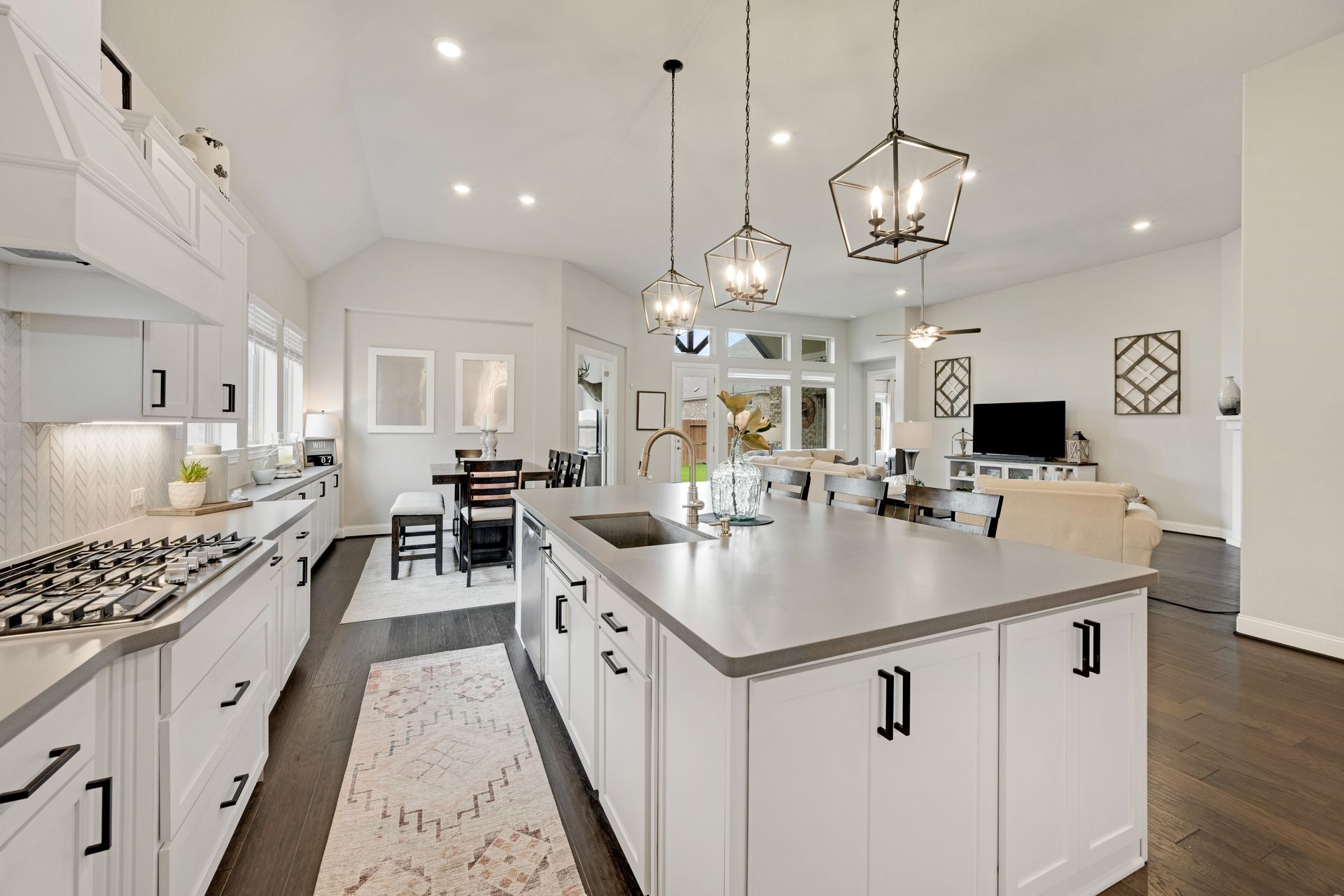 A kitchen with white cabinets and a large island in the middle.
