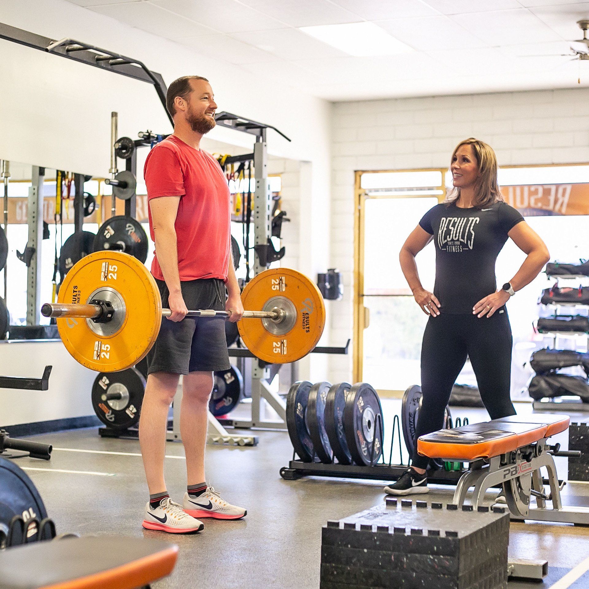 man doing deadlifts with a results fitness coach