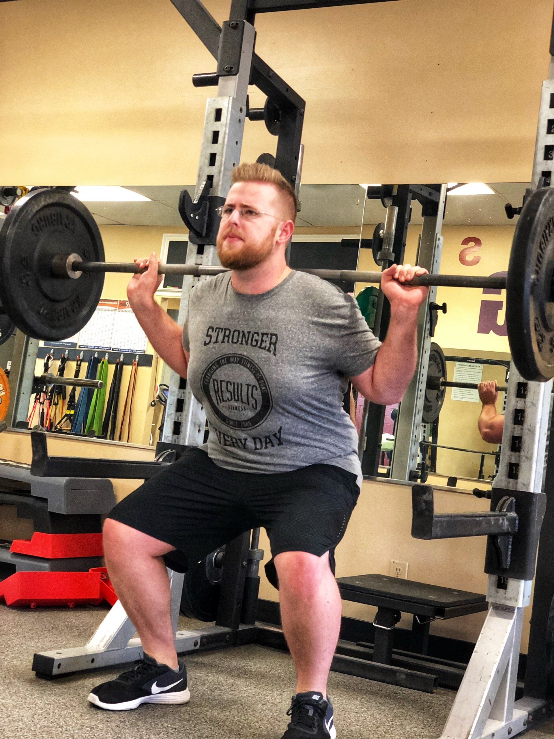 man doing barbell squats