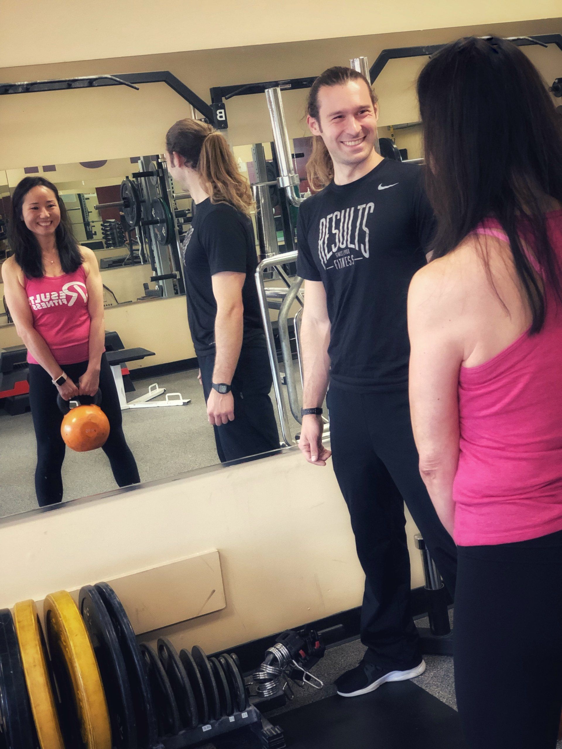 results fitness coach coaching a female client