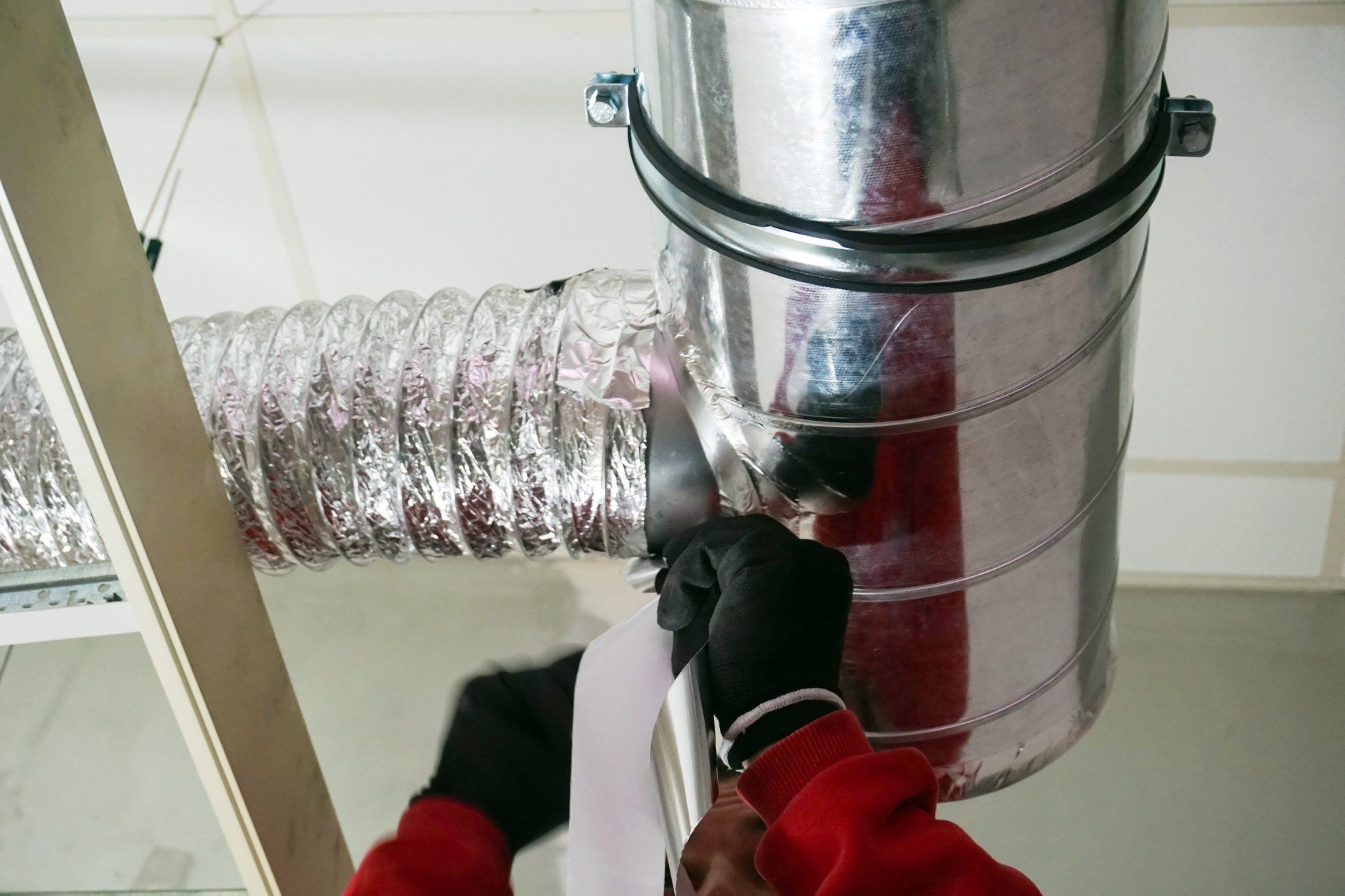A technician performing air duct cleaning and maintenance