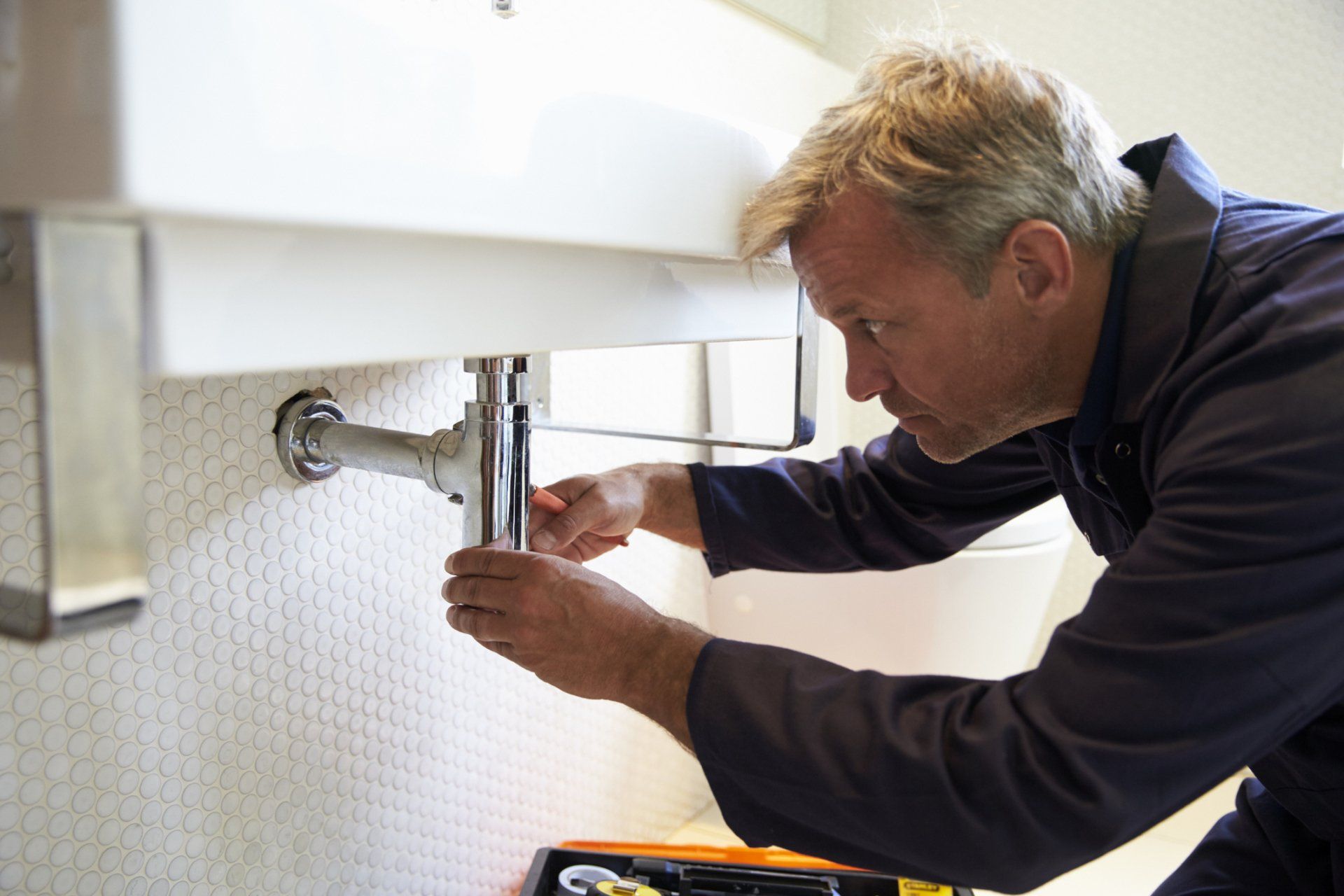 A technician fixing a plumbing system | plumbing and heating and cooling products